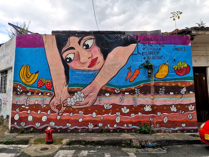A colourful mural of a girl sowing seeds in San Antonio. Visiting this neighbourhood is one of the best things to do in Cali, Colombia!
