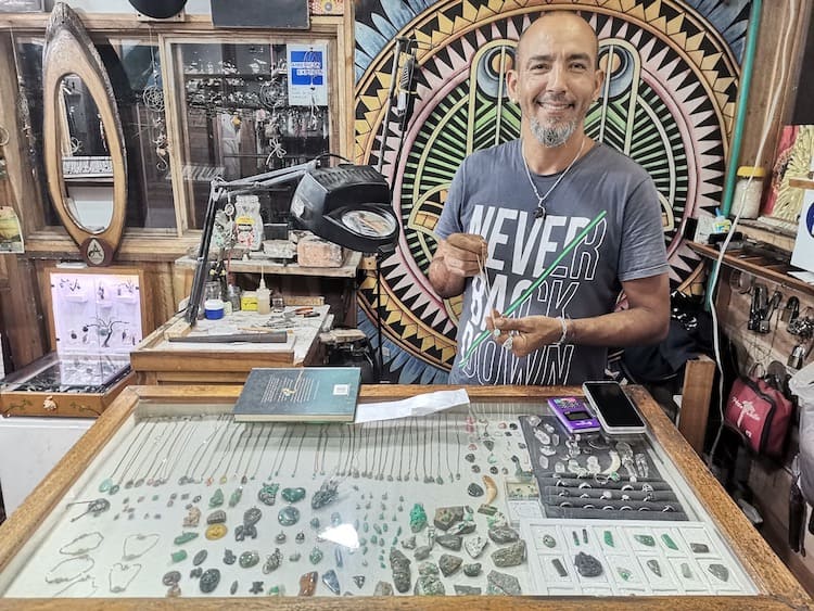 A local man holding up a handmade emerald necklace in a shop in Palomino. Going souvenir shopping is one of my favourite things to do in Palomino!